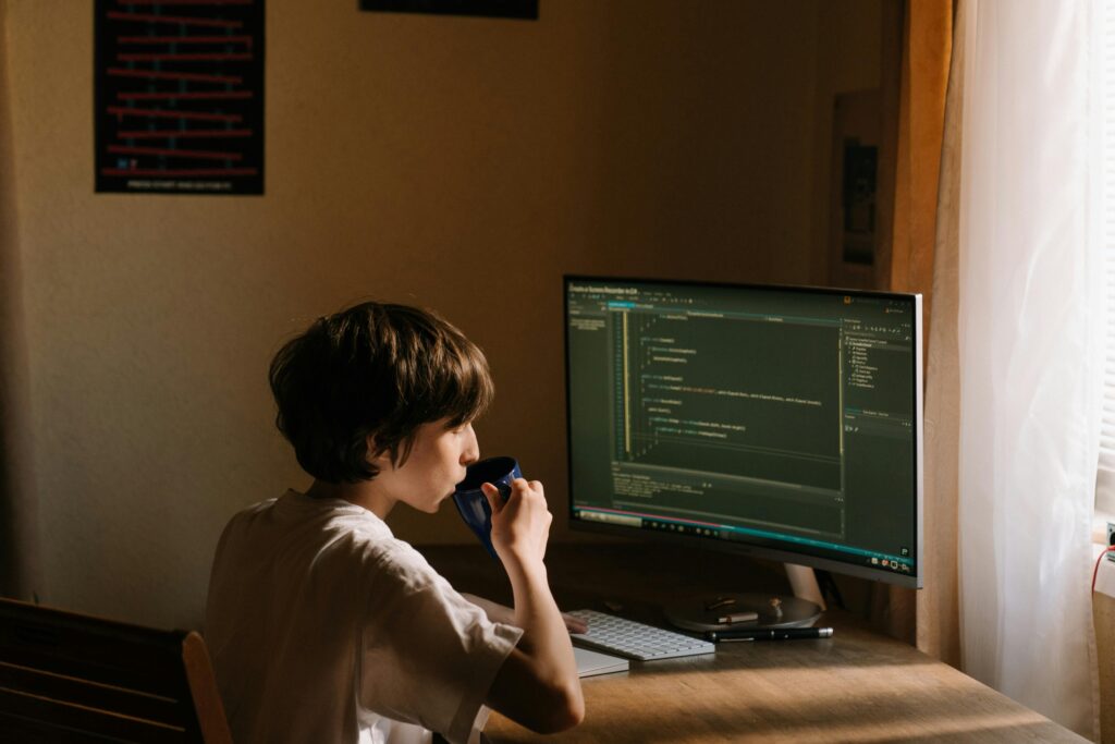 A boy is doing coding with tea