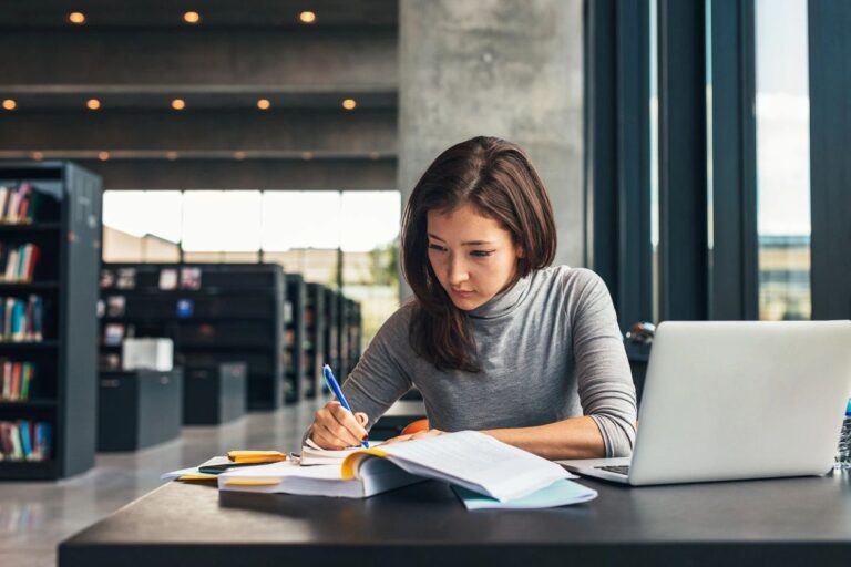 A student is writing something on her notebook